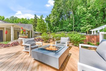 A modern outdoor patio with a fire pit and seating area. at Southpark Commons Apartment Homes, Charlotte